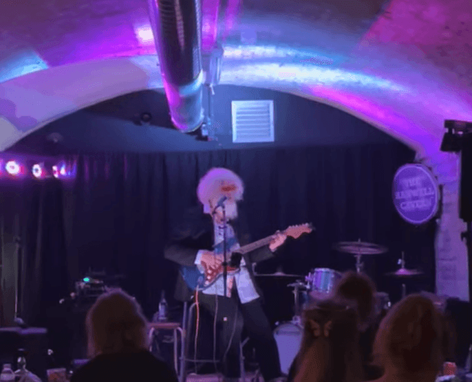 Second Gig ! Let's face it...: a man playing guitar on stage in a dark room